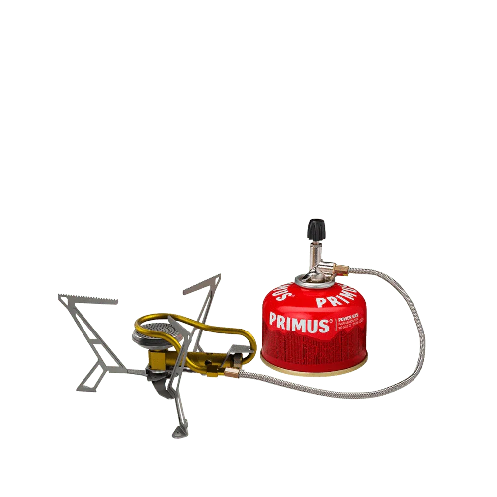 Lightweight camping gas stove with red Primus fuel canister on green background