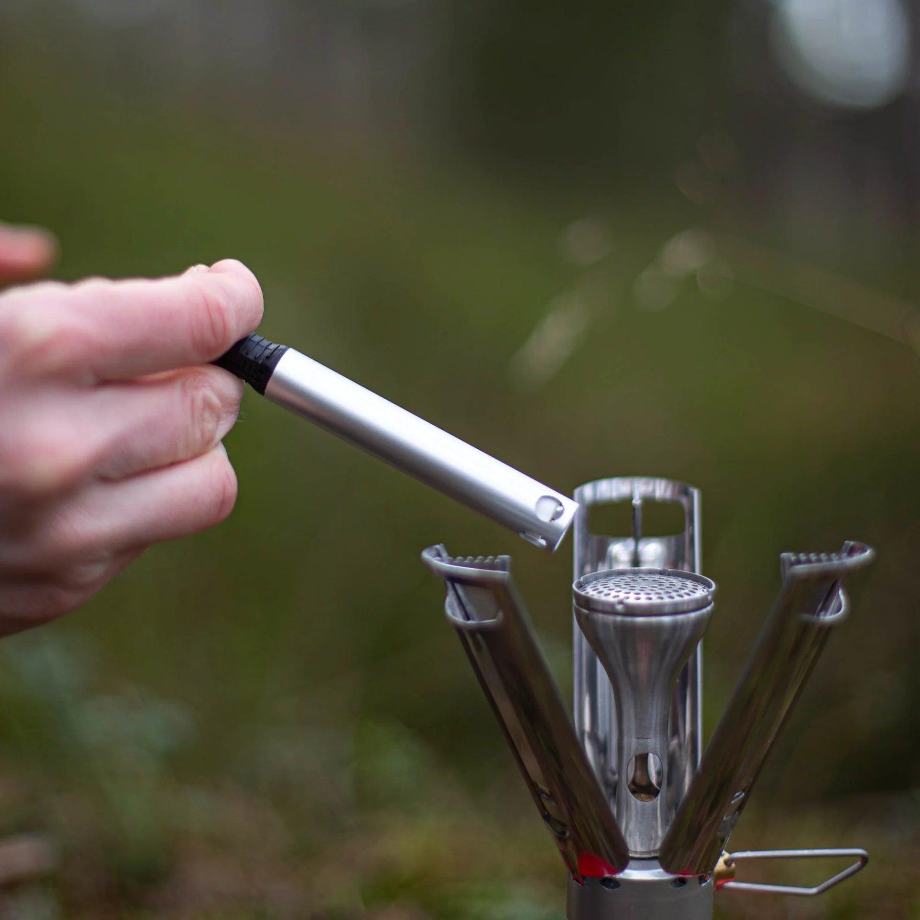 Hand using Primus Piezo igniter stick to light outdoor camping stove
