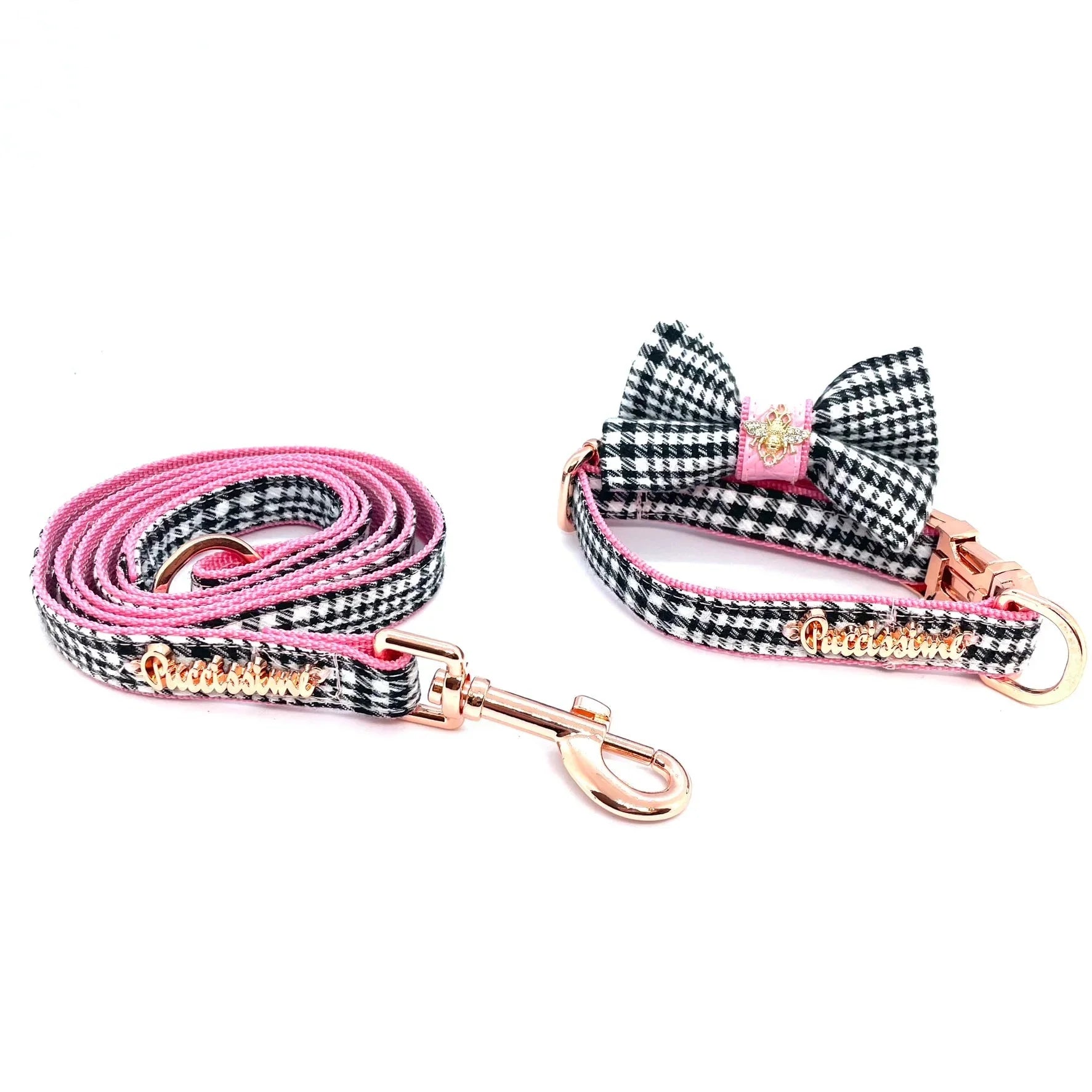 Pink and black plaid dog leash and collar set with bow tie and gold hardware on white background