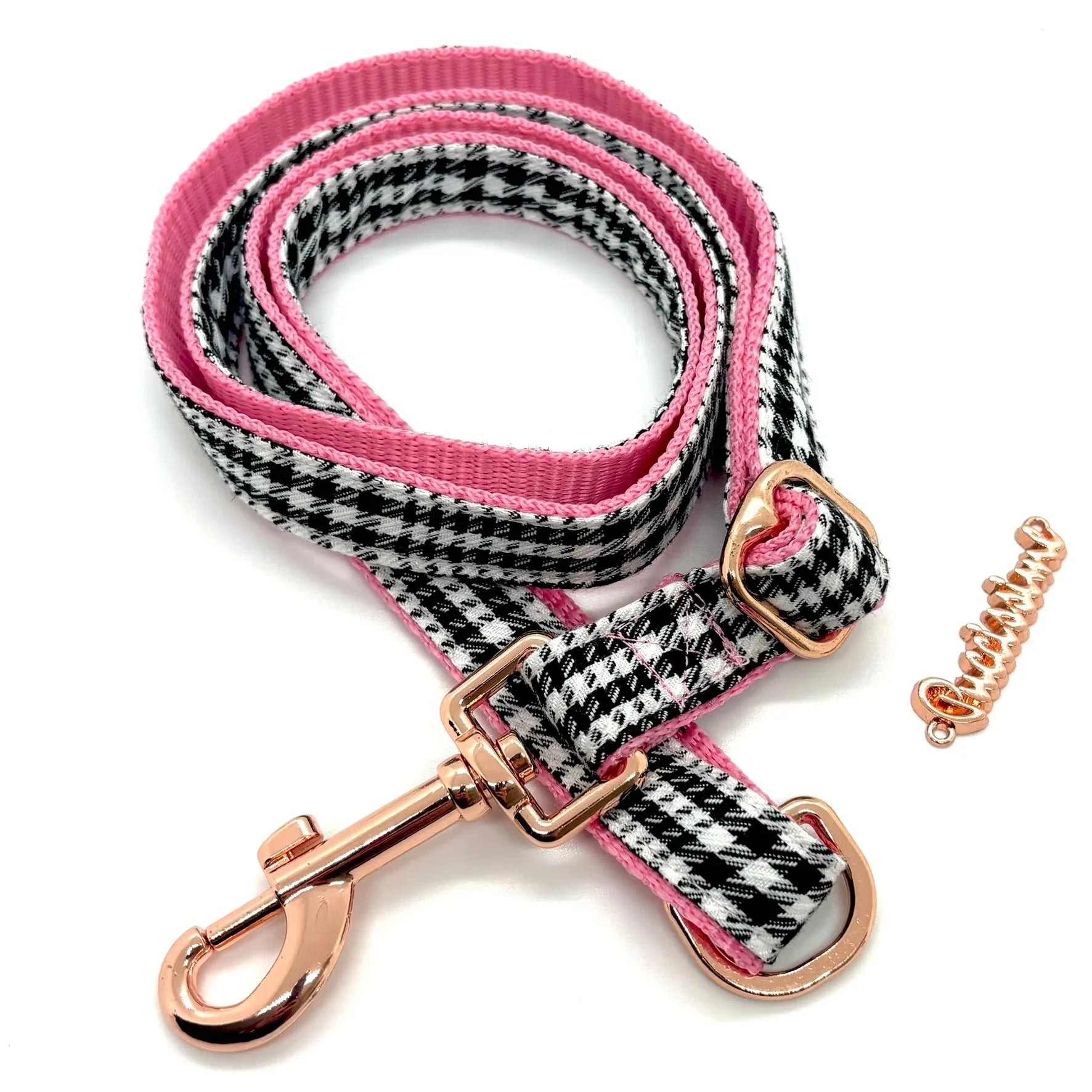 Pink and black houndstooth dog leash with rose gold metal hardware on white background