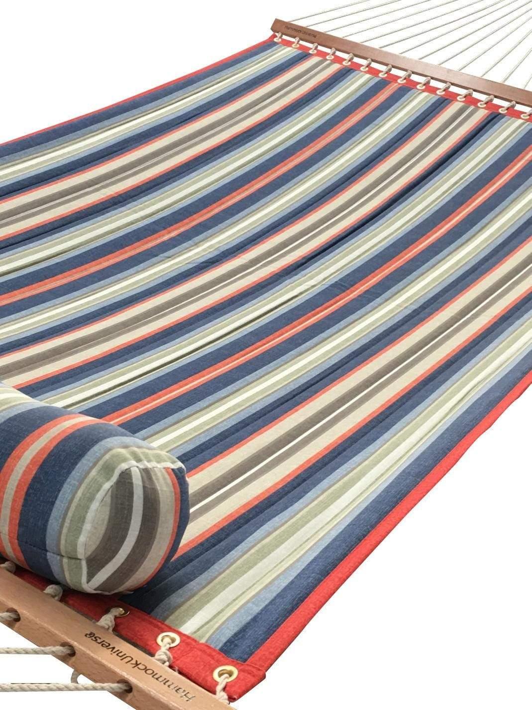 Striped quilted hammock with red, blue, green, and beige pattern and matching pillow