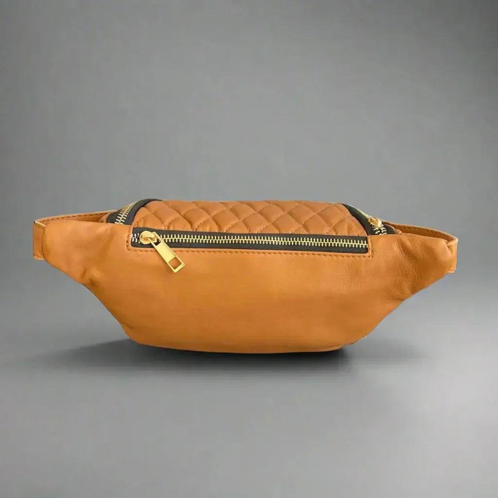 Tan quilted sheep leather waist bag with gold zipper on gray background