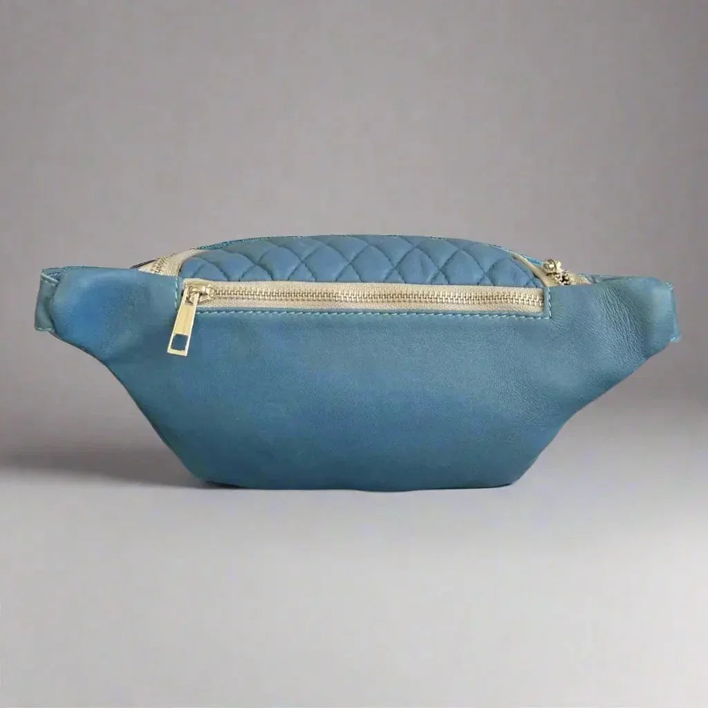 Blue quilted sheep leather waist bag with gold zipper on neutral background