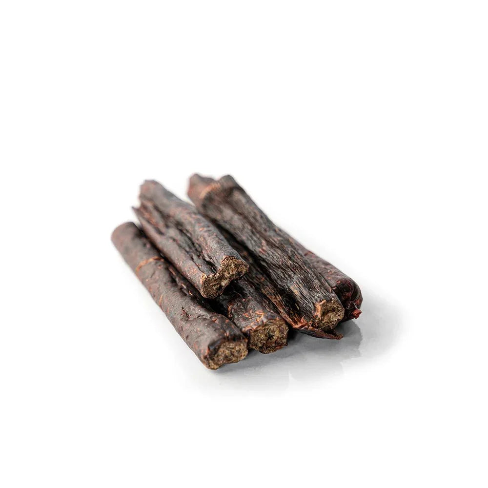 Rabbit beaver sticks dog treats, five dark brown chew sticks on white background