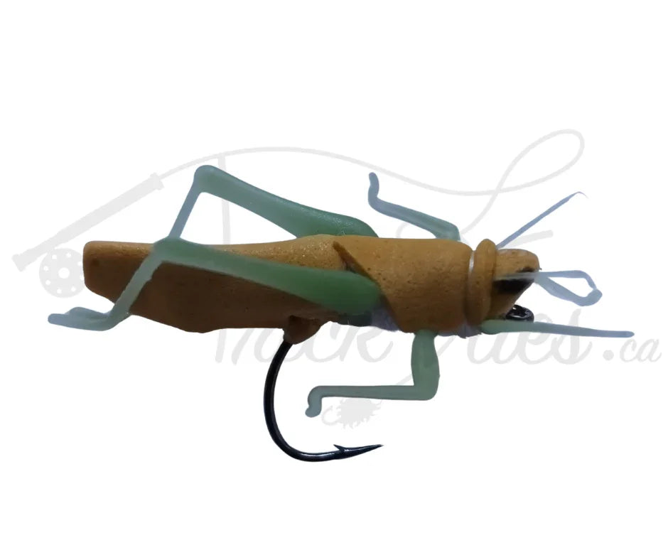 Realistic cinnamon brown hopper fishing fly with green legs and black hook on white background