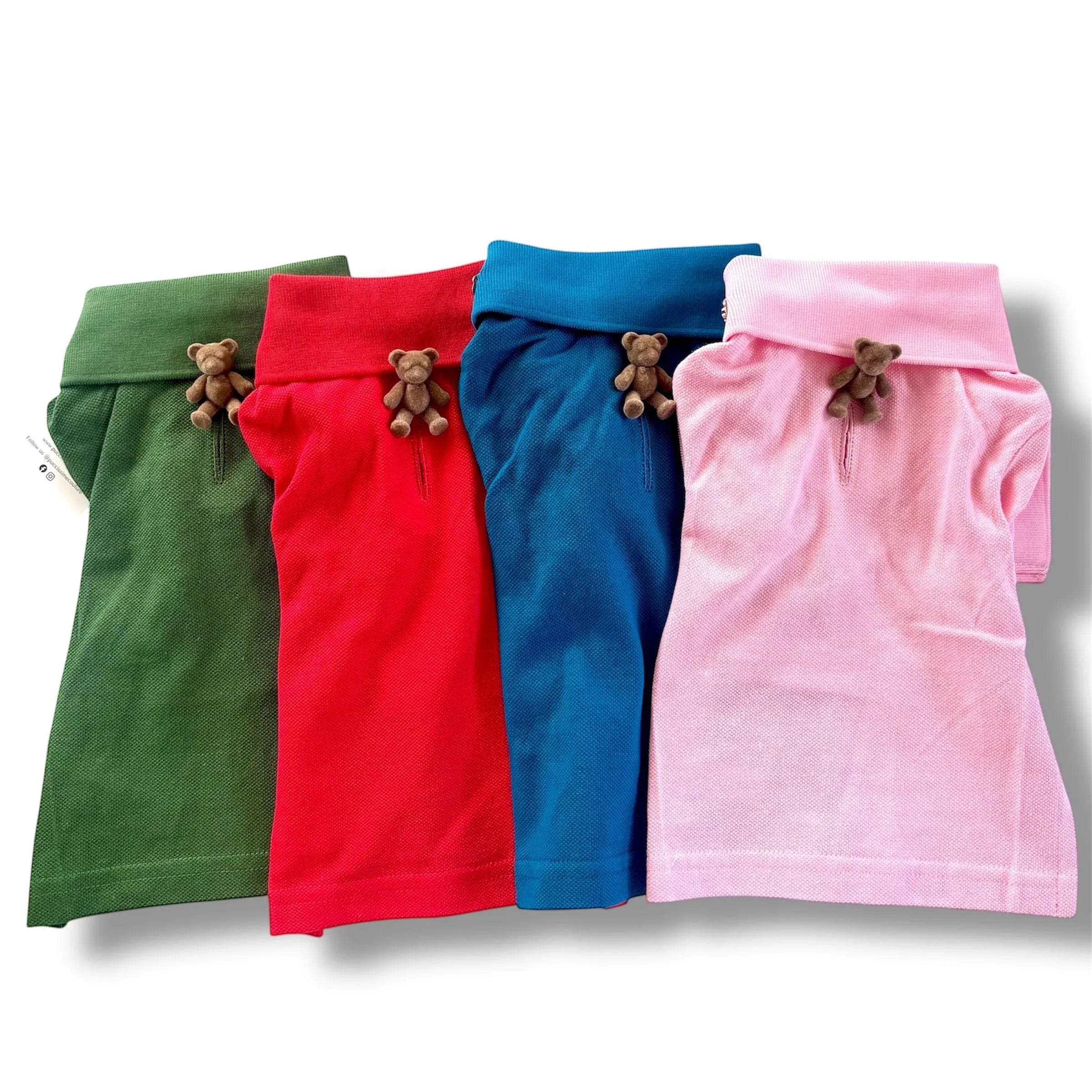 Four colorful dog shirts with teddy bear decorations in green, red, blue, and pink.