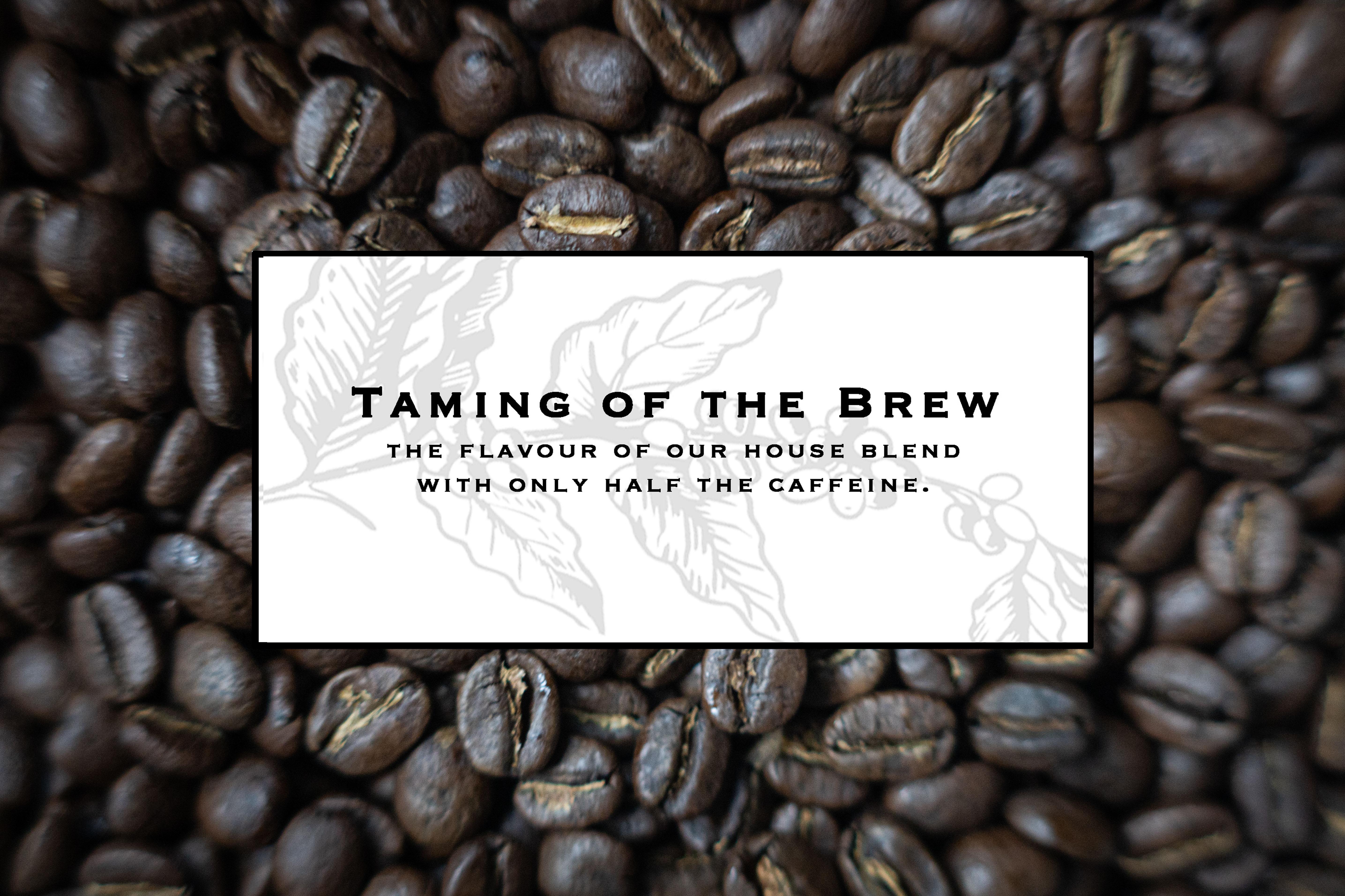 Taming of the Brew coffee label over roasted coffee beans, half caffeine house blend.