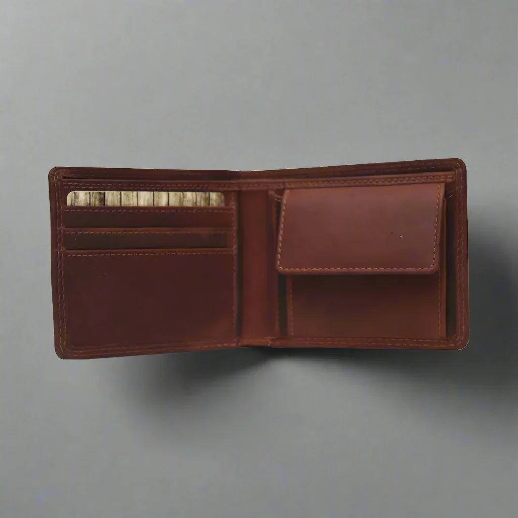 Open brown men's leather bifold wallet with card slots and coin pocket on gray background