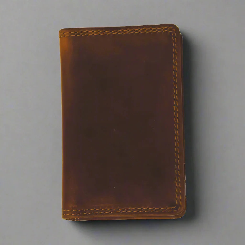 Brown leather men's credit card wallet with visible stitching on a gray background