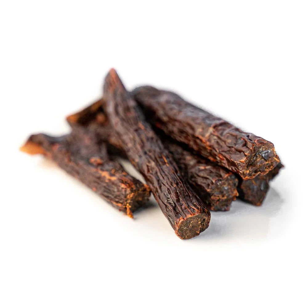 Salmon beef tripe sticks dog treats stacked on white background