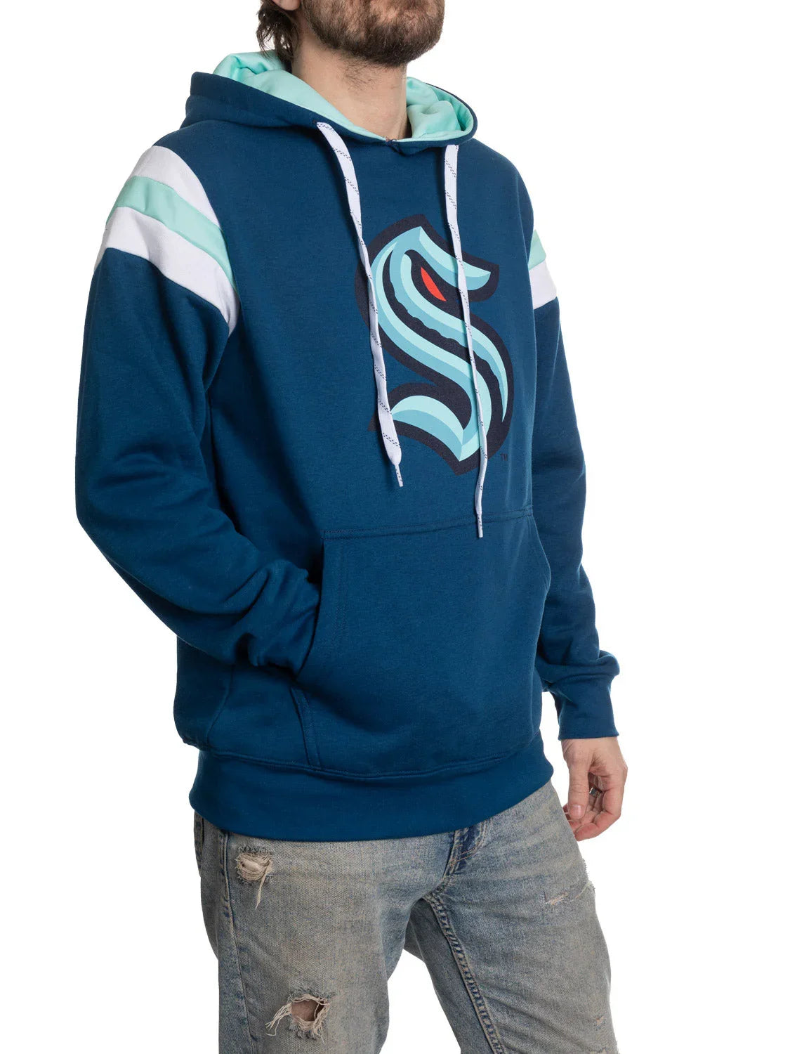 Man wearing Seattle Kraken varsity hoodie with logo, blue and aqua stripes, and ripped jeans