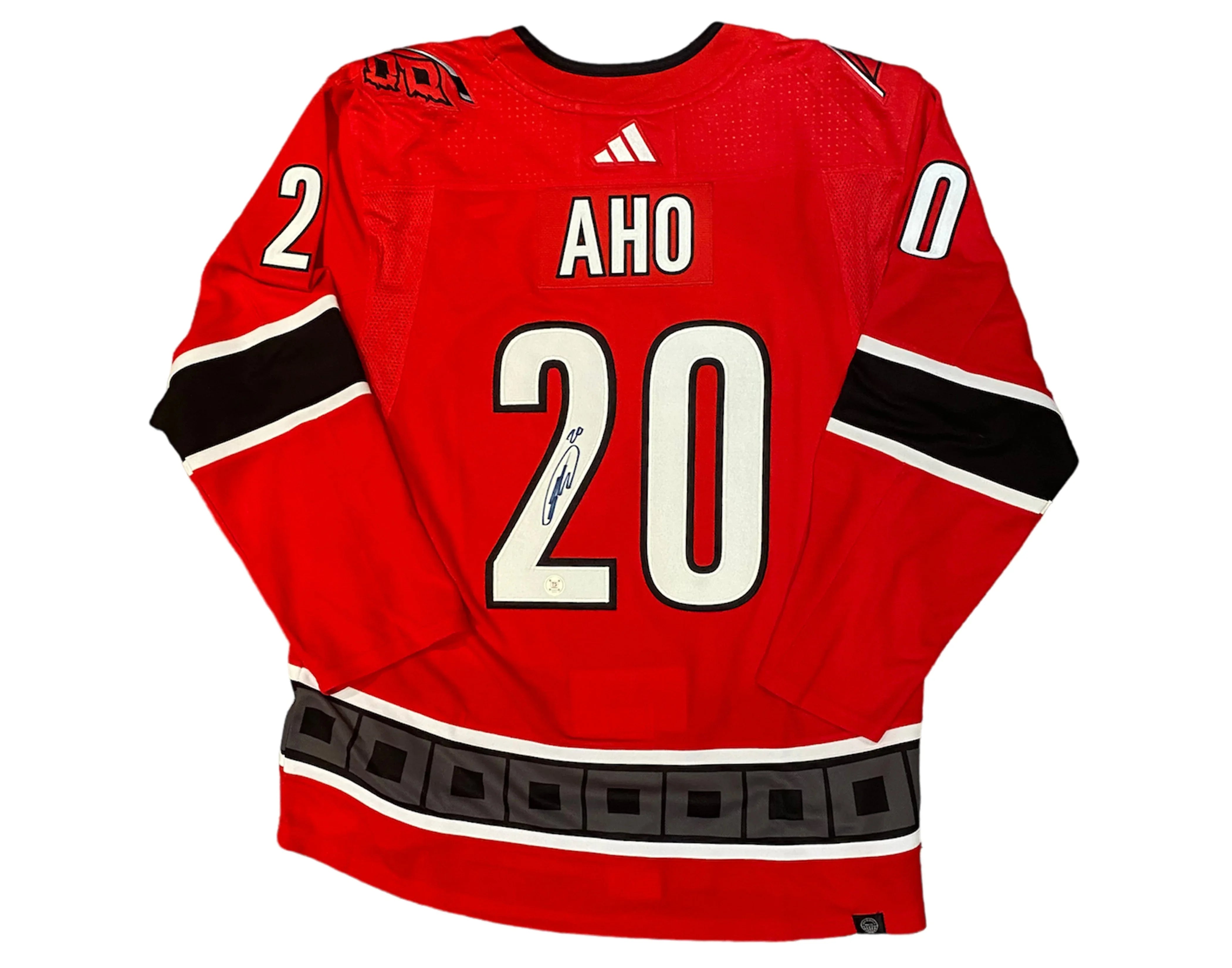 Red hockey jersey with name Aho and number 20, black and white accents, autograph on 2
