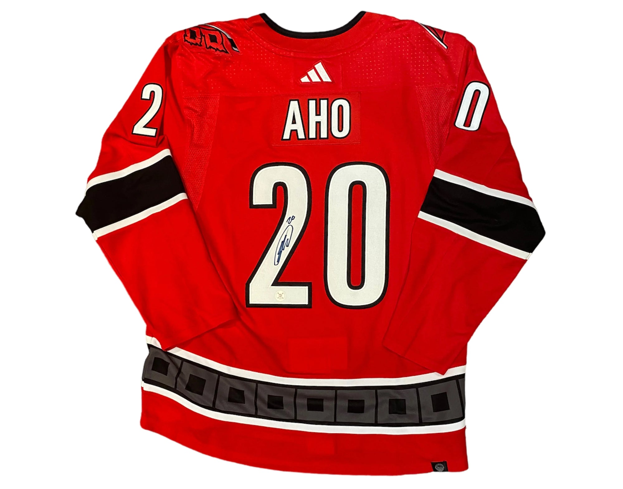 Red hockey jersey with name Aho and number 20, black and white accents, autograph on 2