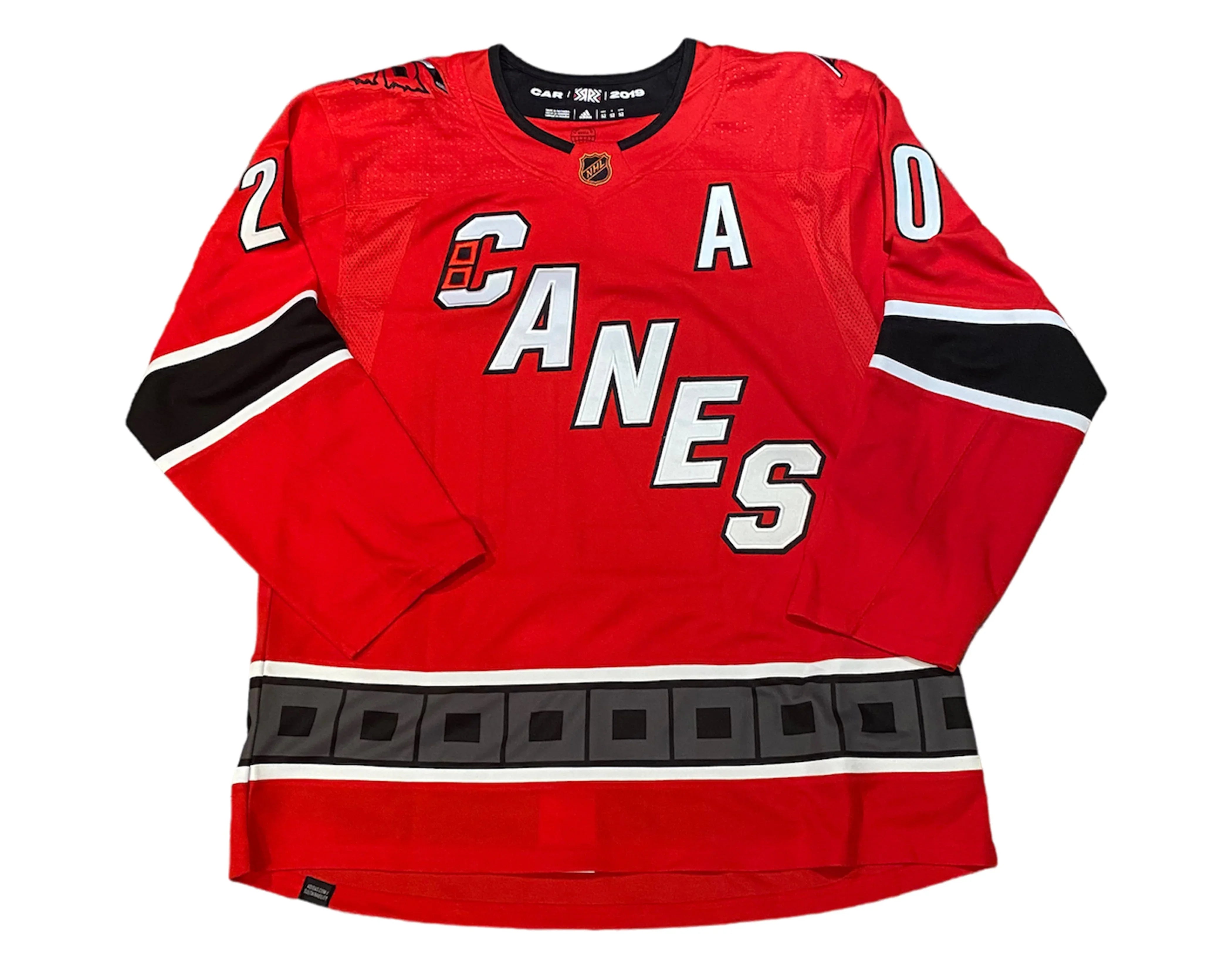 Red Carolina Hurricanes hockey jersey with bold CANES lettering and black sleeve stripes