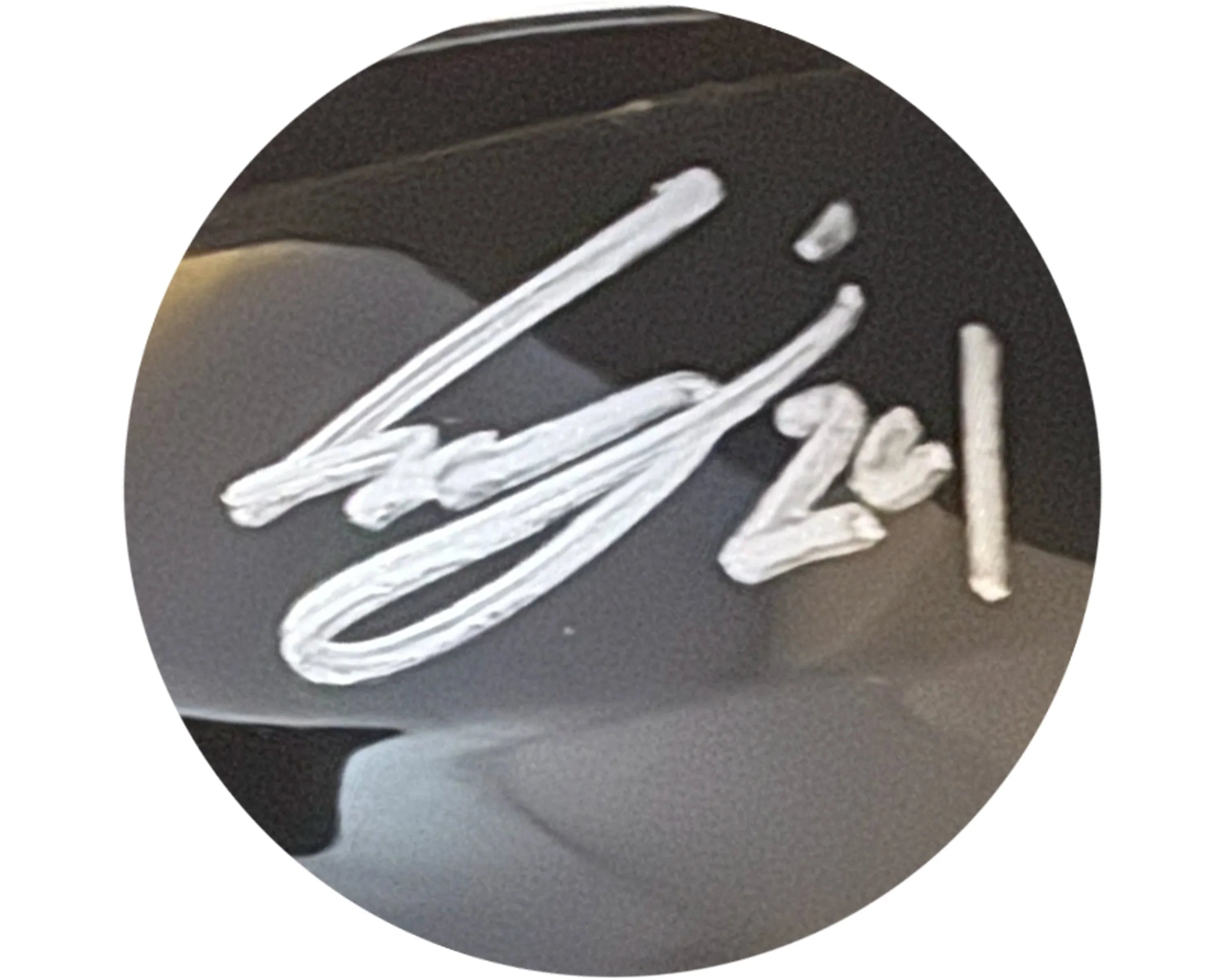 White signature on glossy black surface, close-up autograph collectible.