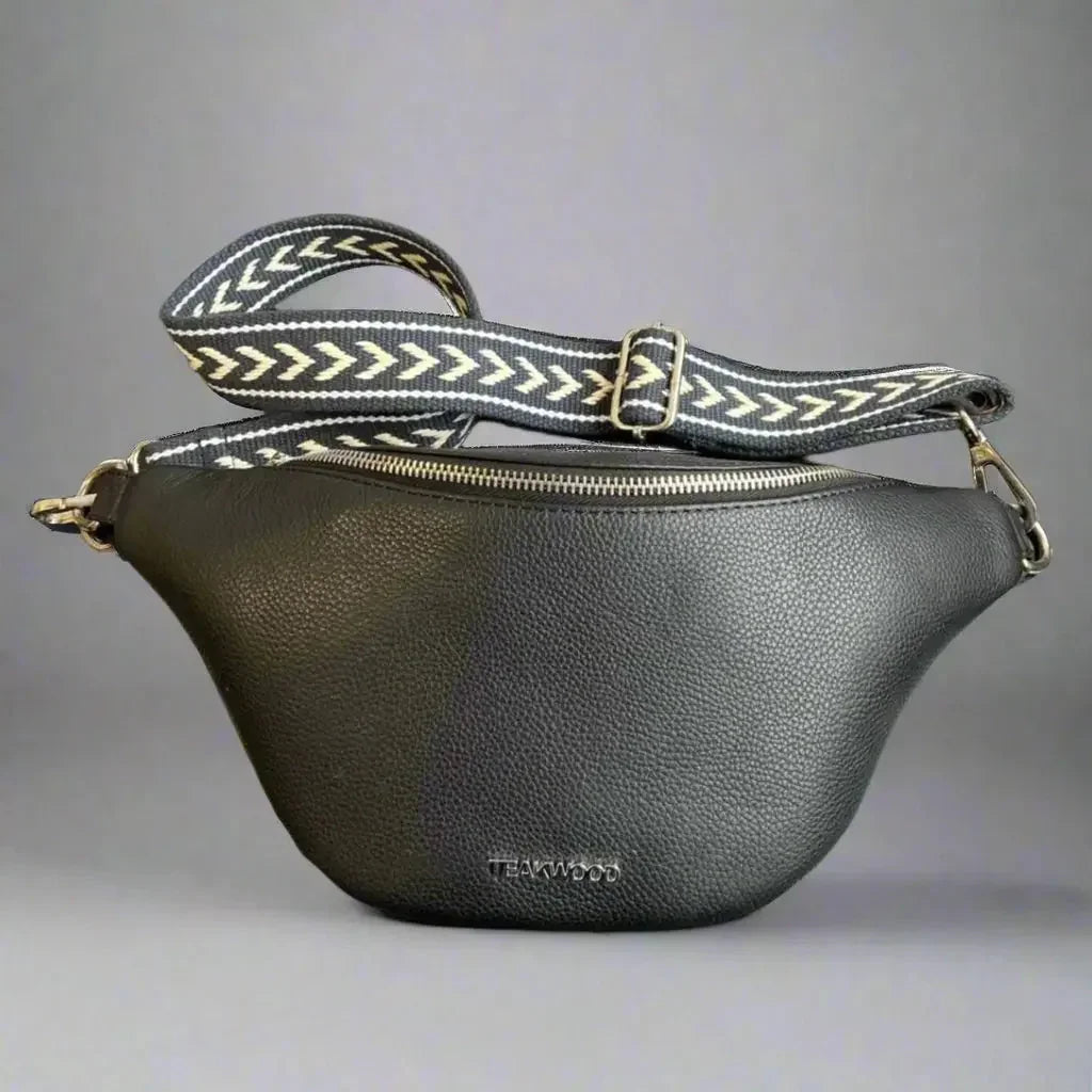 Black sheep leather waist bag with patterned strap and gold hardware on a gray background