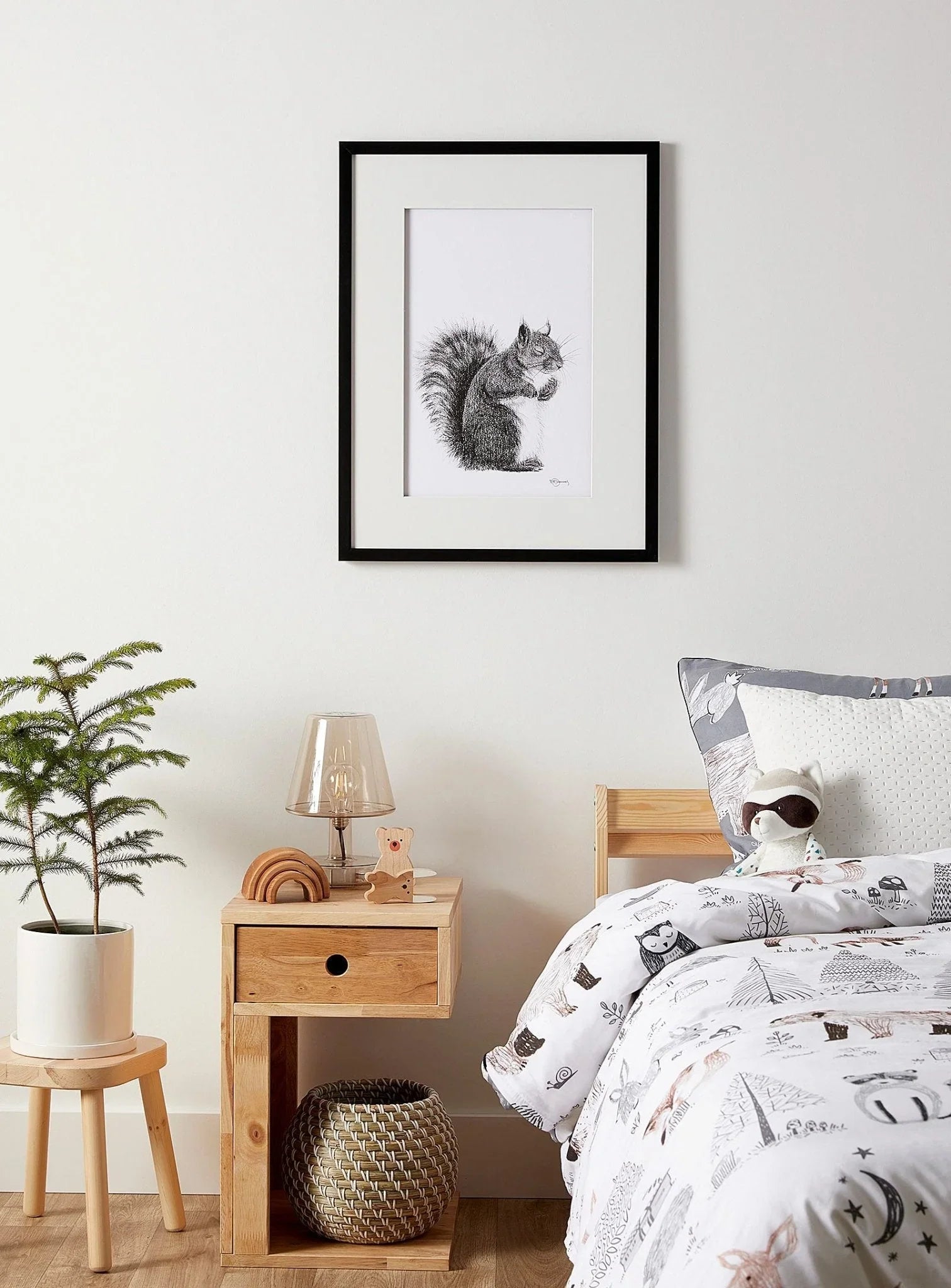 Framed squirrel illustration above a cozy kids bedroom with animal-themed decor