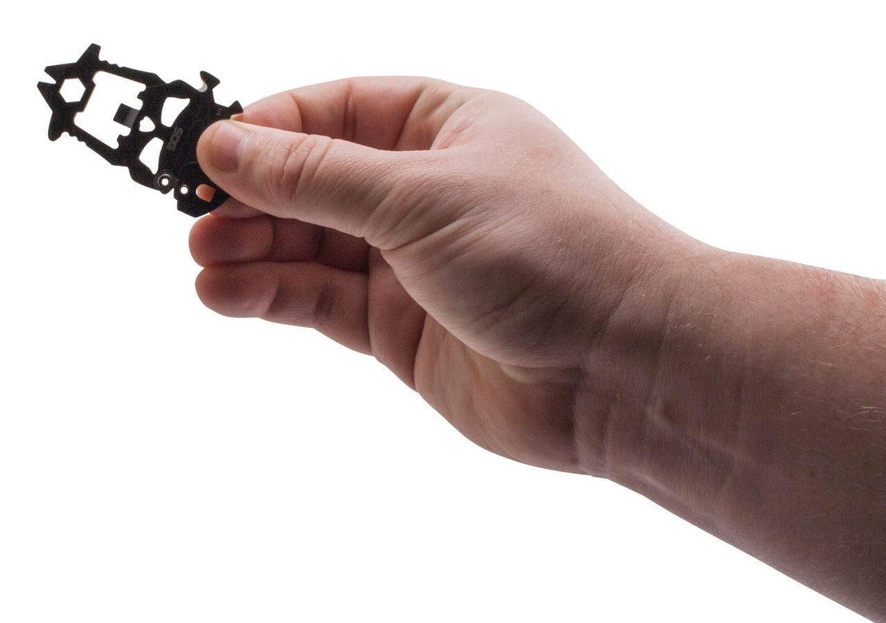 Hand holding SOG MACV Tool multitool against white background