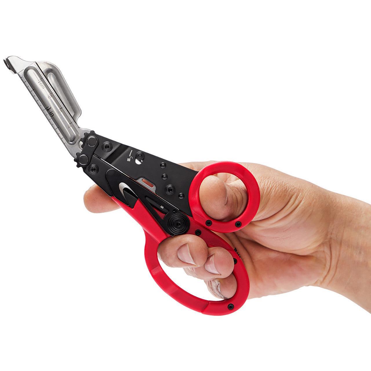 Hand holding SOG ParaShears multi-tool with red handles and stainless steel blades