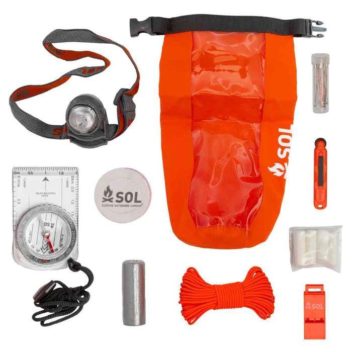 SOL Adventure Ready survival kit with orange dry bag, headlamp, compass, paracord, and survival tools.