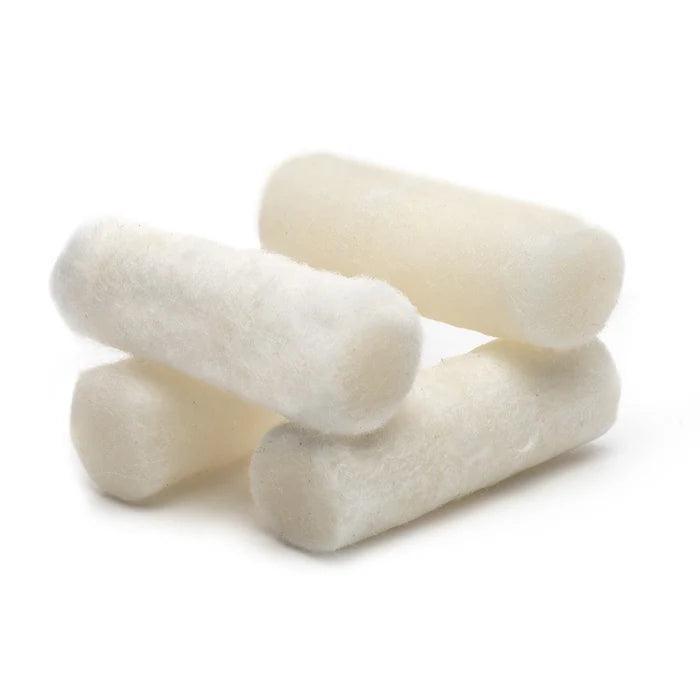 Four white cotton tinder sticks stacked for outdoor fire starting