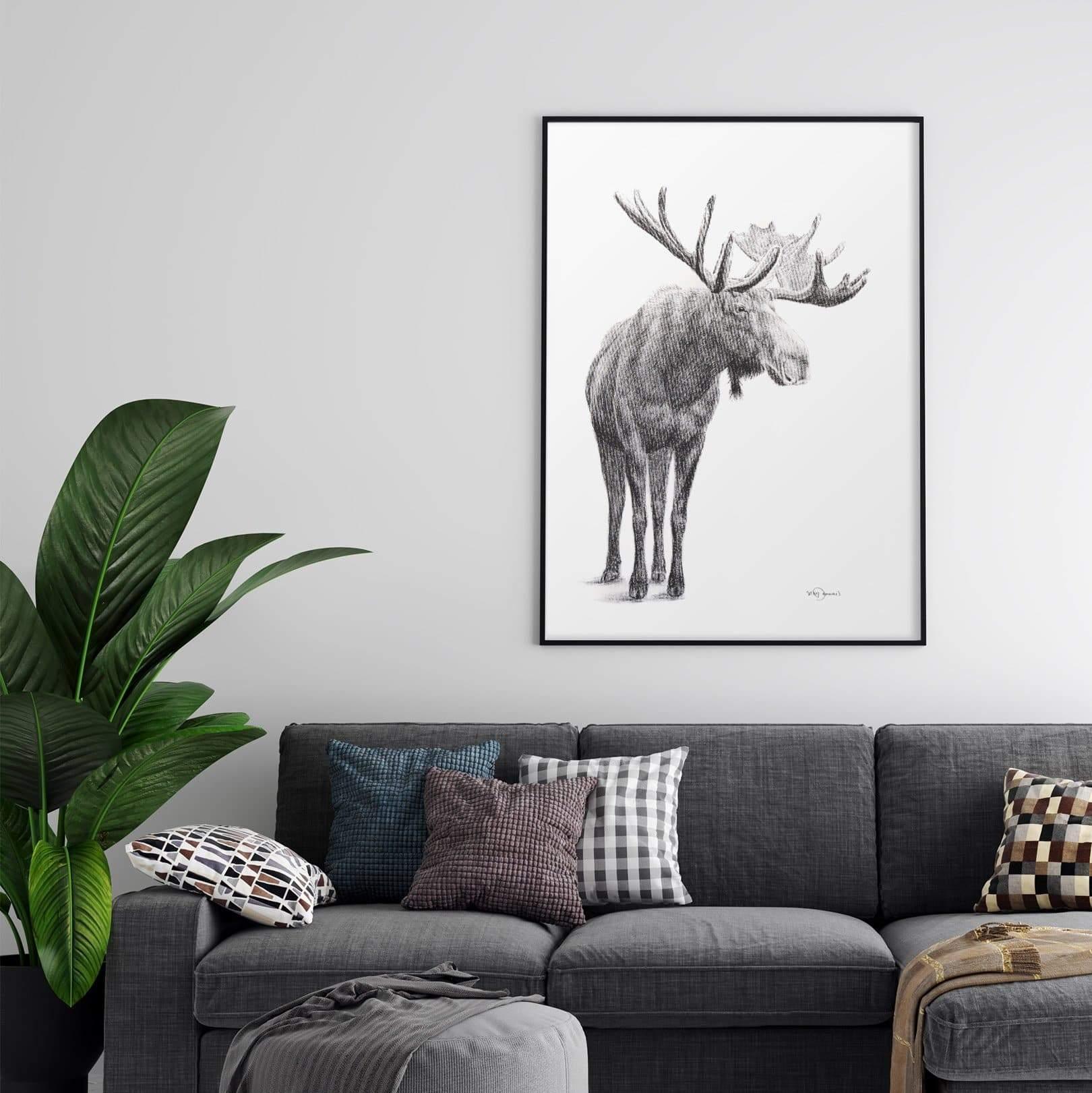 Modern living room with gray sofa, patterned pillows, large moose wall art, and green plant