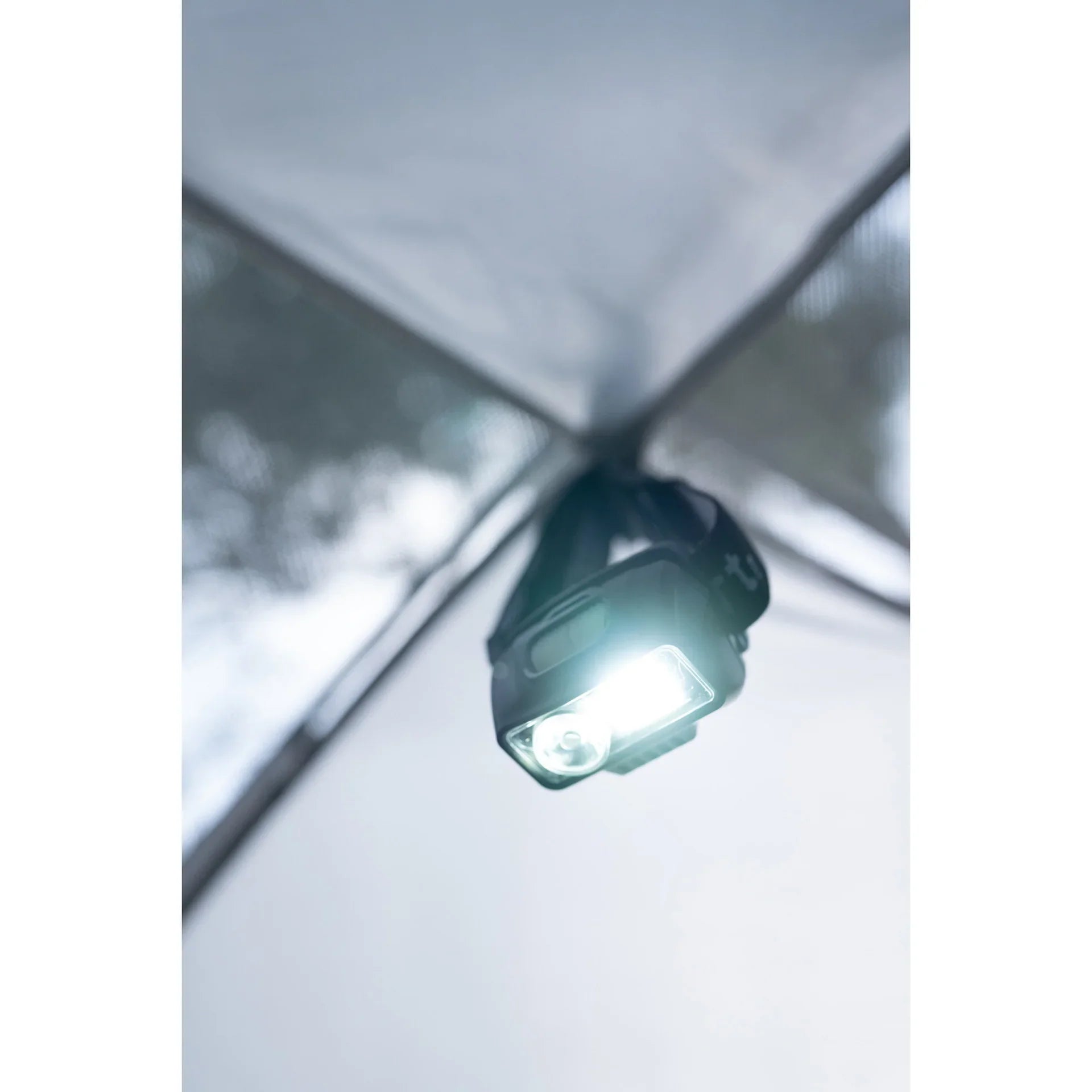 Bright LED headlamp hanging inside a tent for camping lighting
