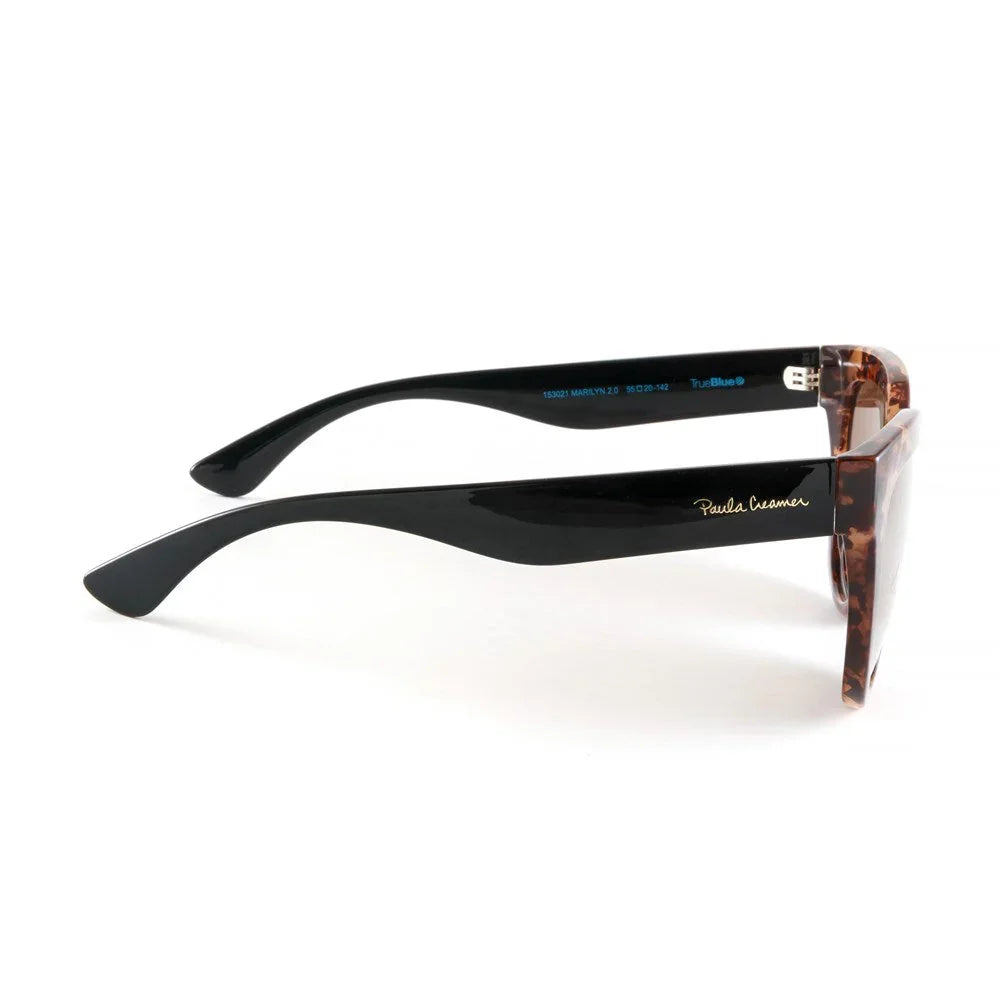 Side view of Paula Creamer black and tortoiseshell sunglasses on white background