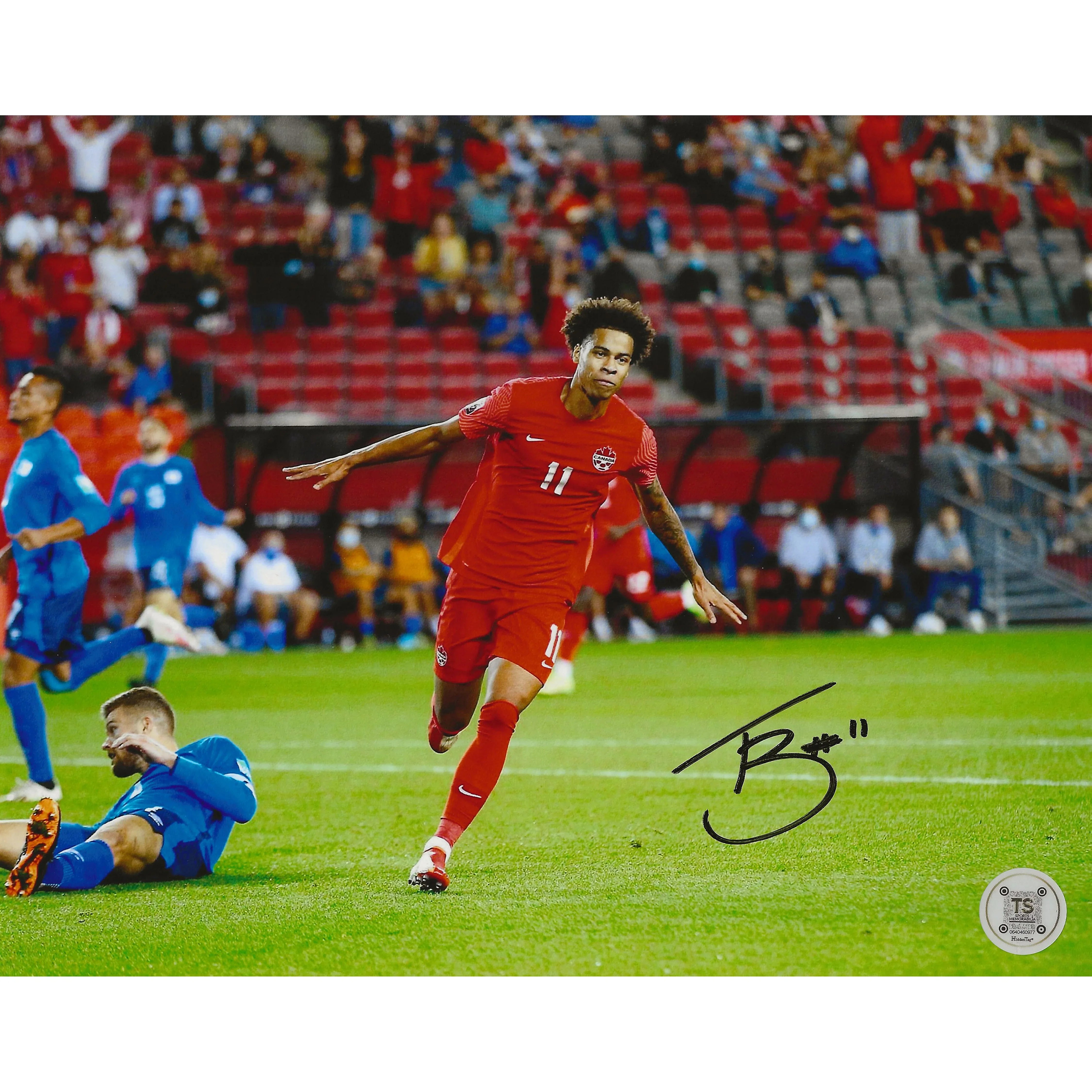 Canada soccer player in red jersey celebrating goal on field, autograph, stadium crowd