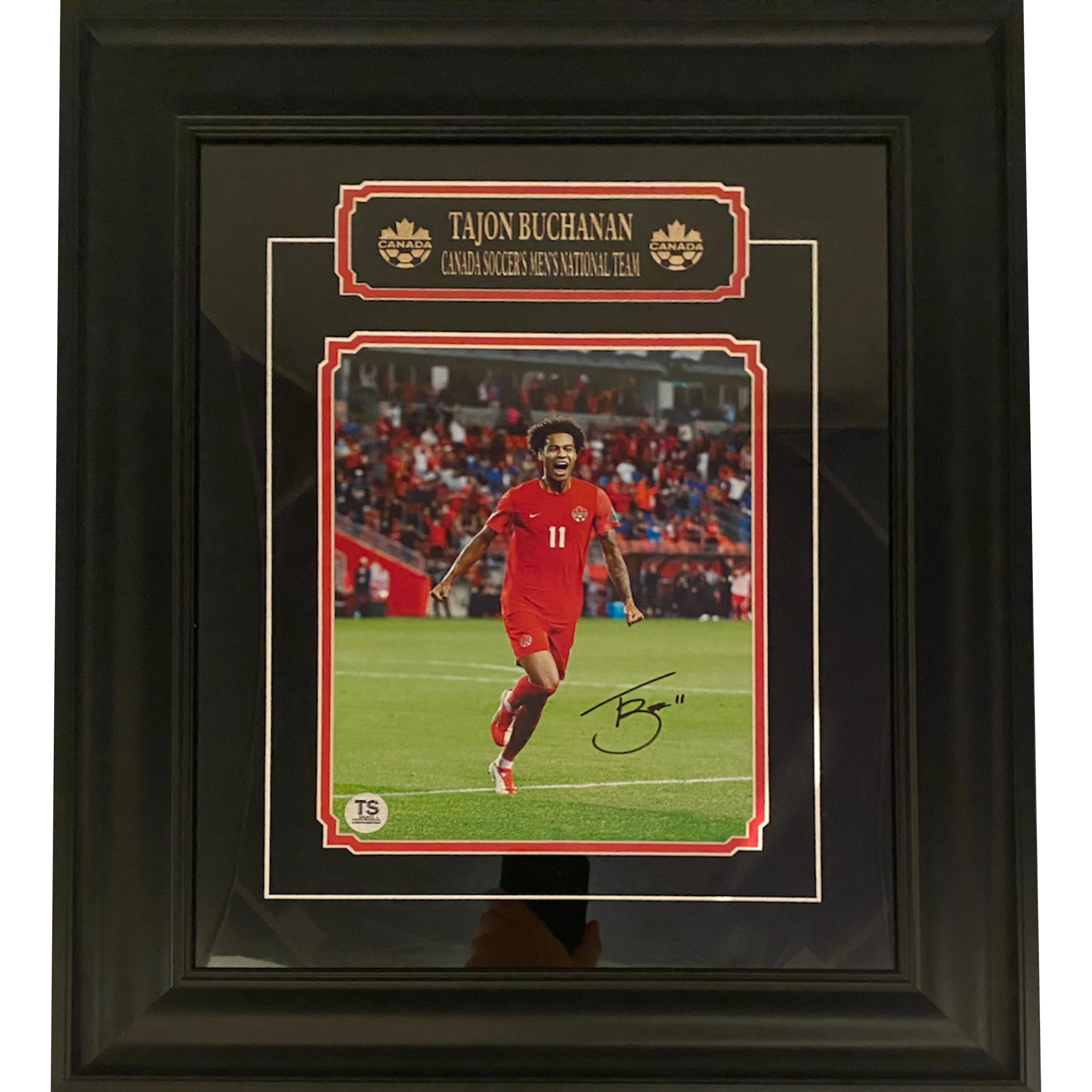 Framed signed photo of Tajon Buchanan in Canada soccer jersey, running on field, stadium crowd