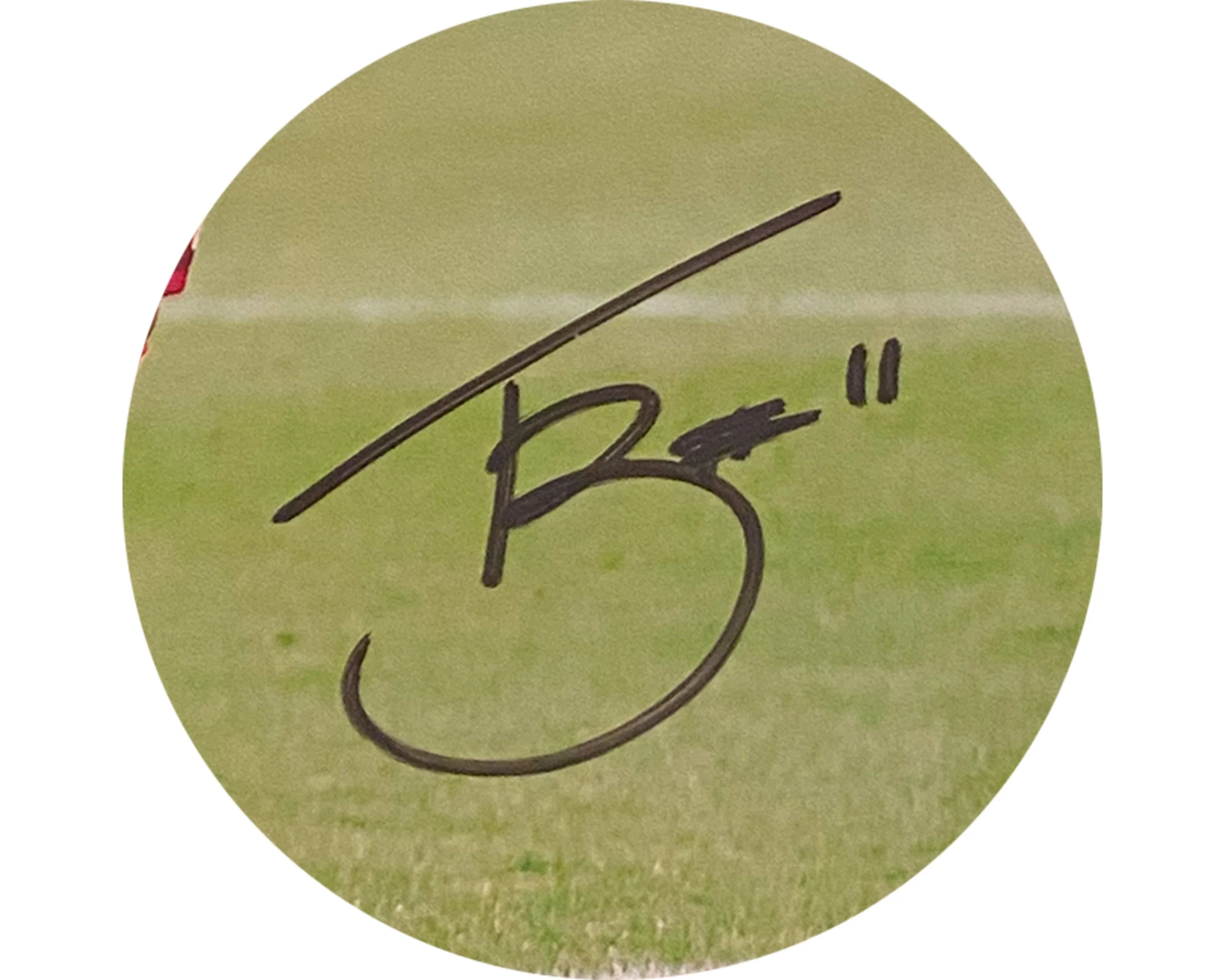 Black signature with number 11 on green grass sports field background