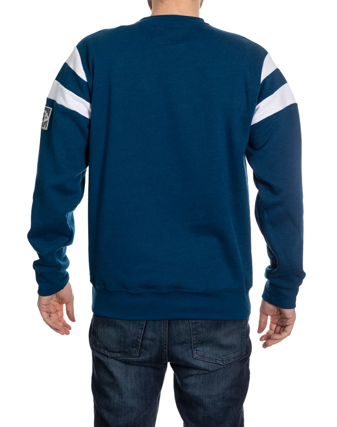 Man wearing blue sweatshirt with white stripes on sleeves and dark jeans, back view