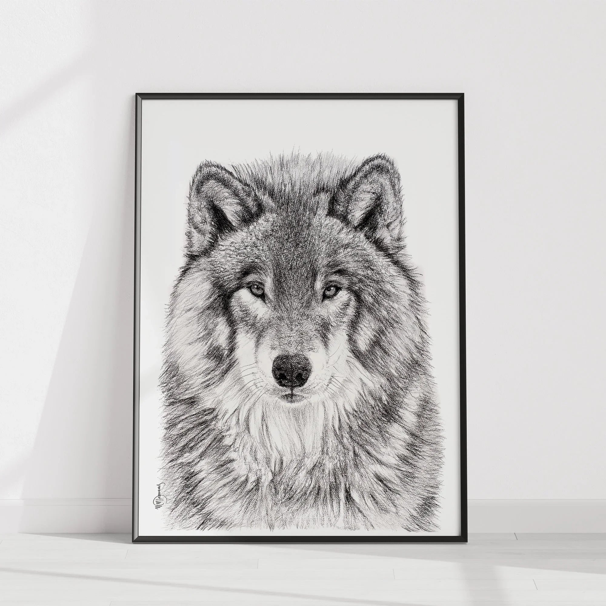 Wolf portrait art print in black frame leaning against white wall on light wood floor
