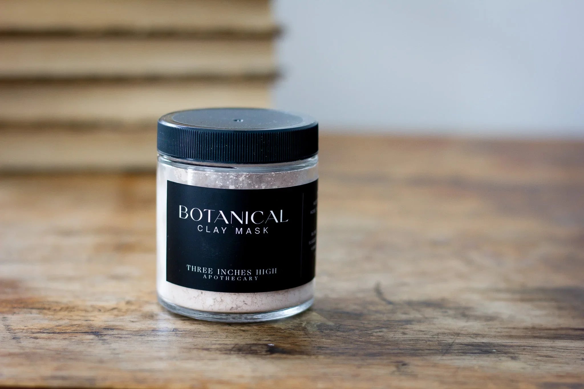 Botanical clay mask jar by Three Inches High Apothecary on rustic wooden table