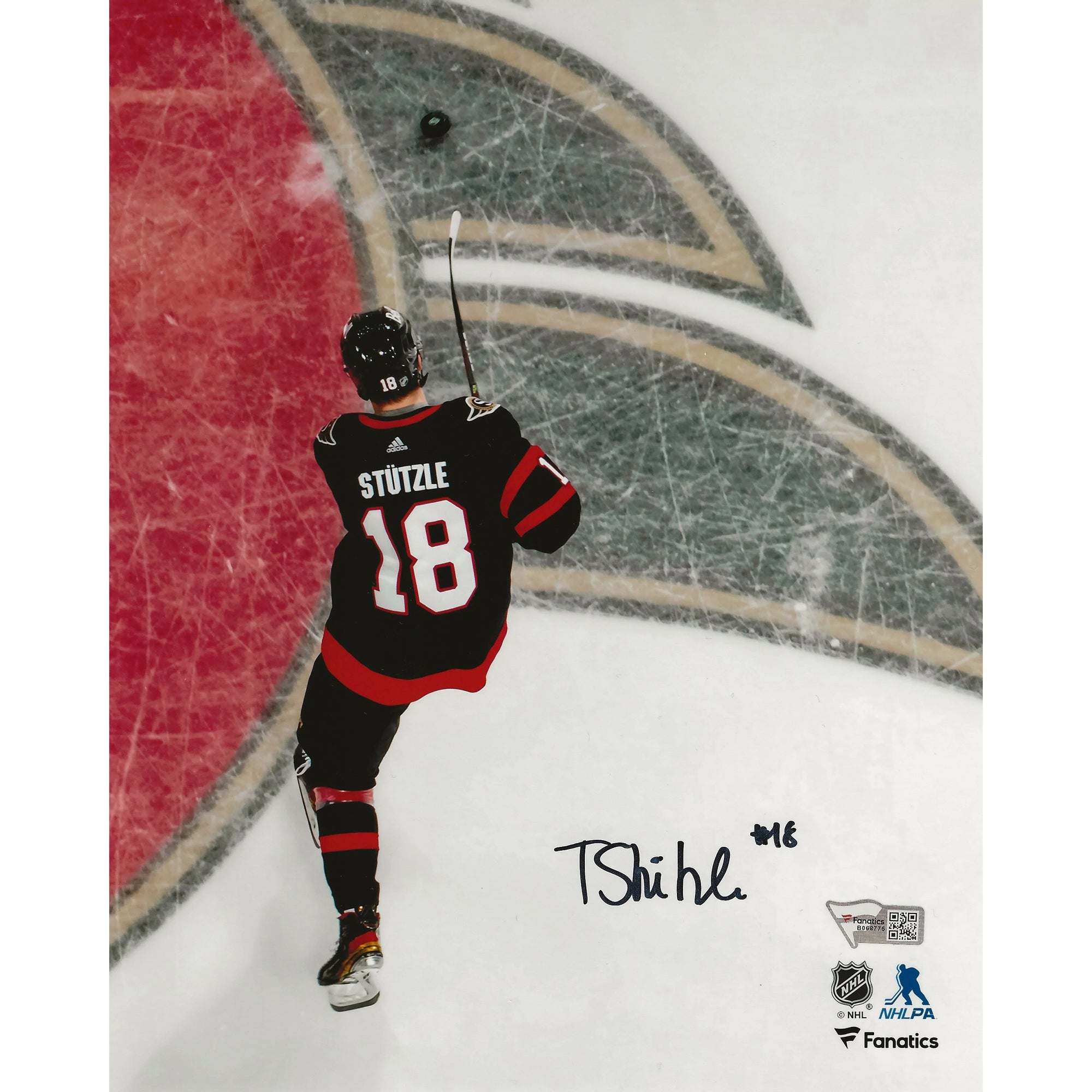 Ice hockey player in black jersey 18 Stützle skating on rink with puck, autograph visible