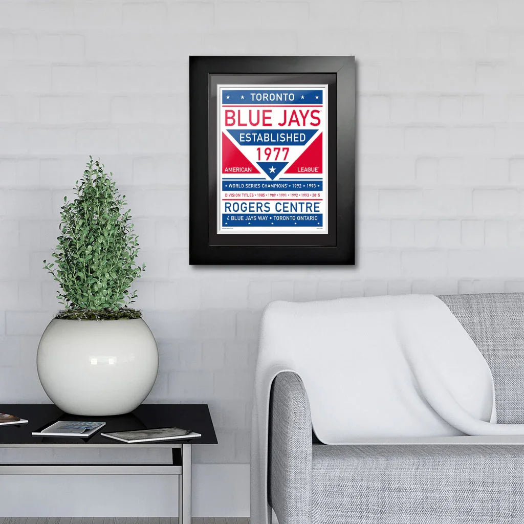 Toronto Blue Jays framed artwork on wall above gray sofa in modern living room