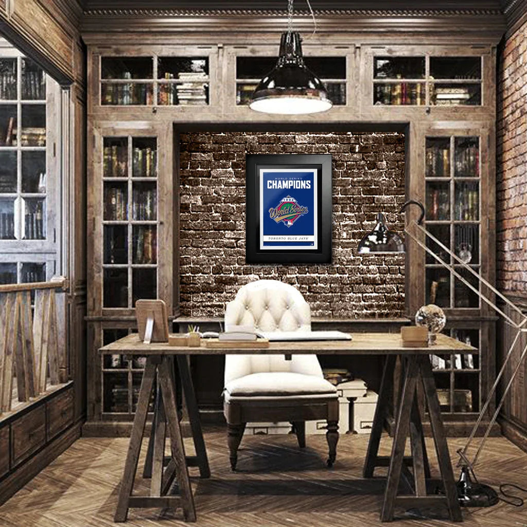 Vintage office with wooden desk, white chair, brick wall, Toronto Blue Jays 1992 World Series Champions framed poster