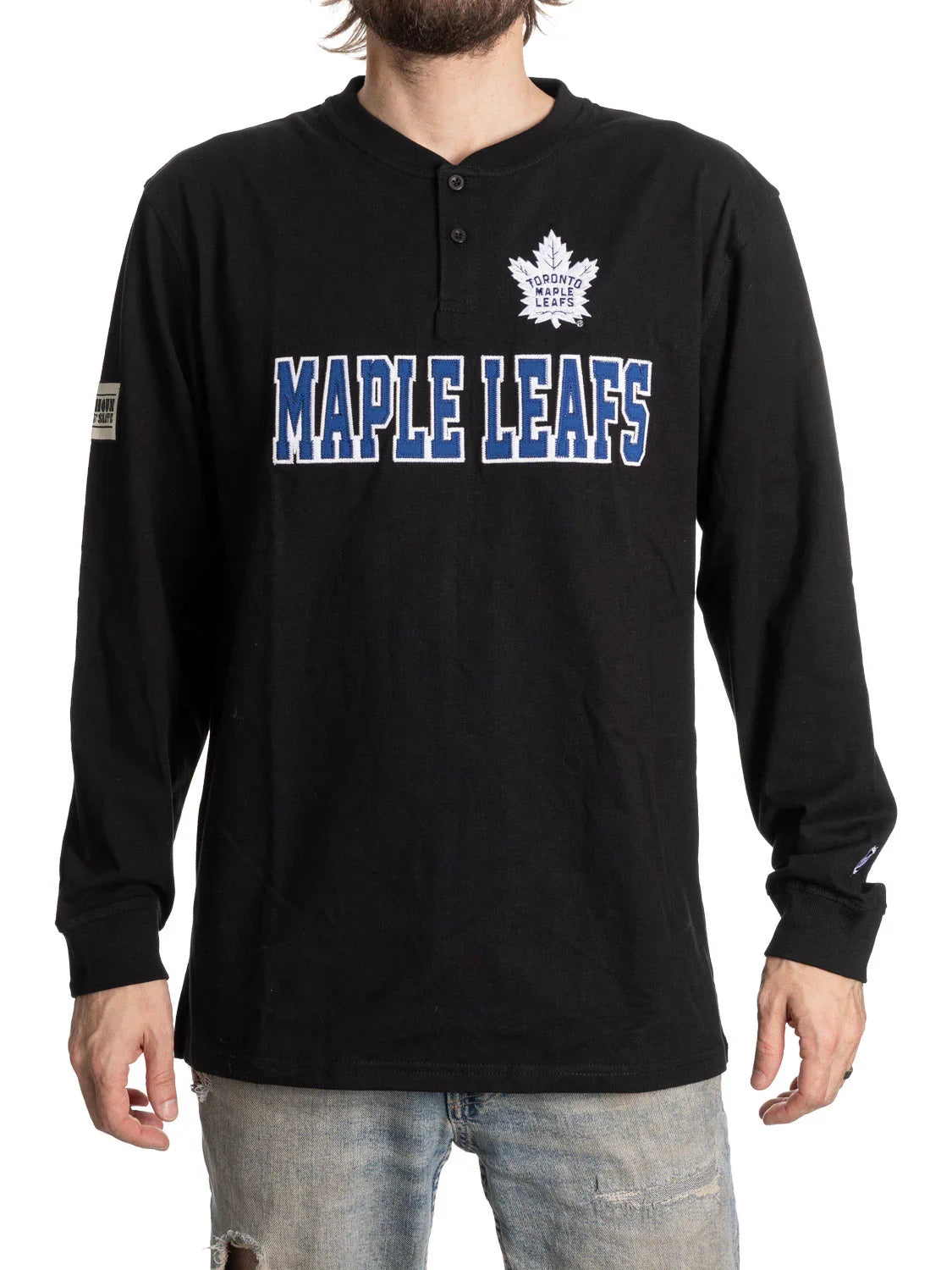 Man wearing black Toronto Maple Leafs henley long sleeve shirt and distressed jeans