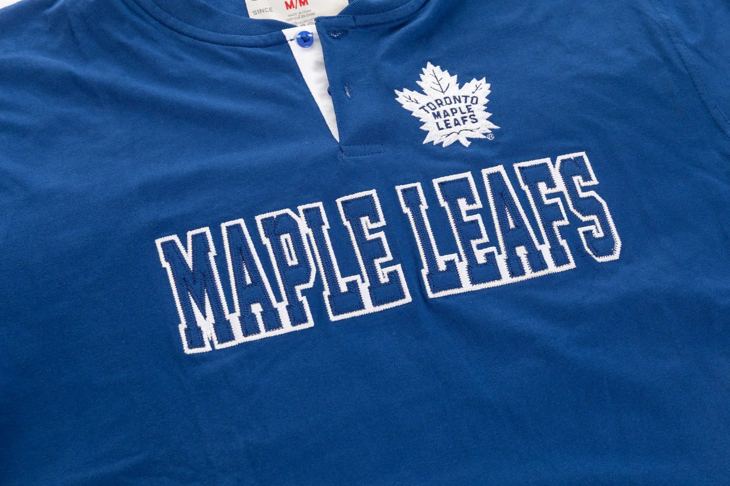 Blue Toronto Maple Leafs henley shirt with embroidered logo and team name on chest.