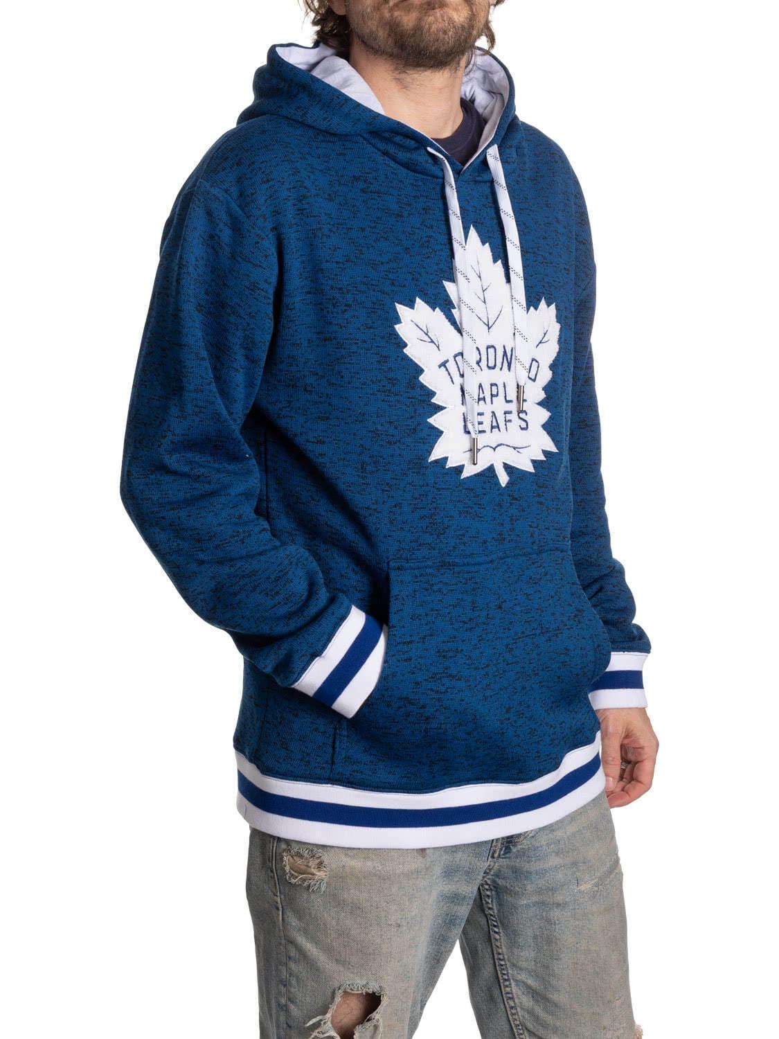 Man wearing blue Toronto Maple Leafs hoodie with white stripes and distressed jeans