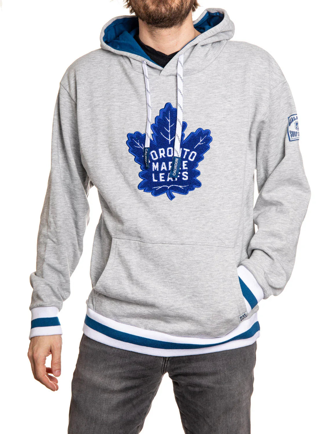 Man wearing grey Toronto Maple Leafs chenille logo hoodie with blue and white trim