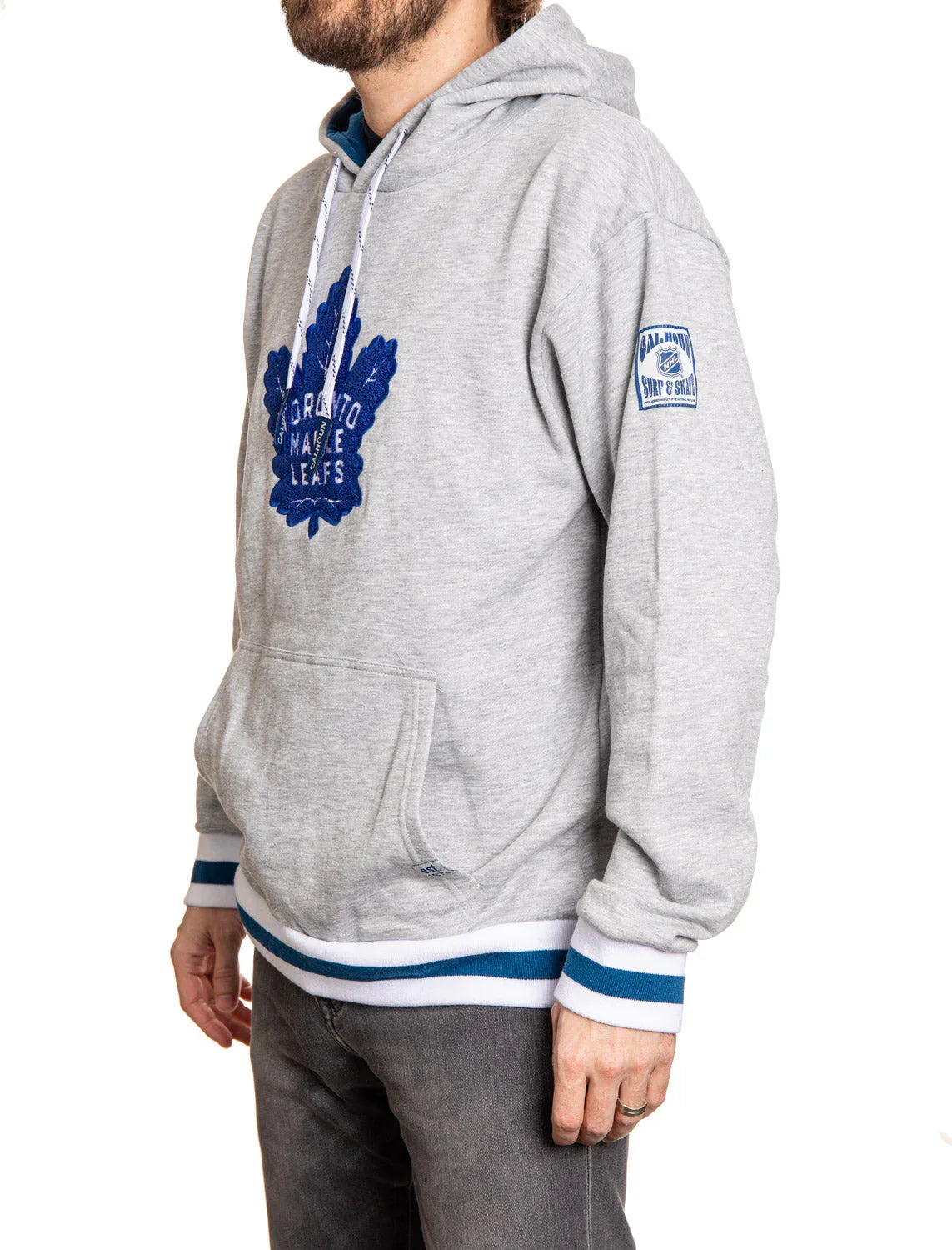 Man wearing grey Toronto Maple Leafs chenille hoodie with blue maple leaf logo and blue trim