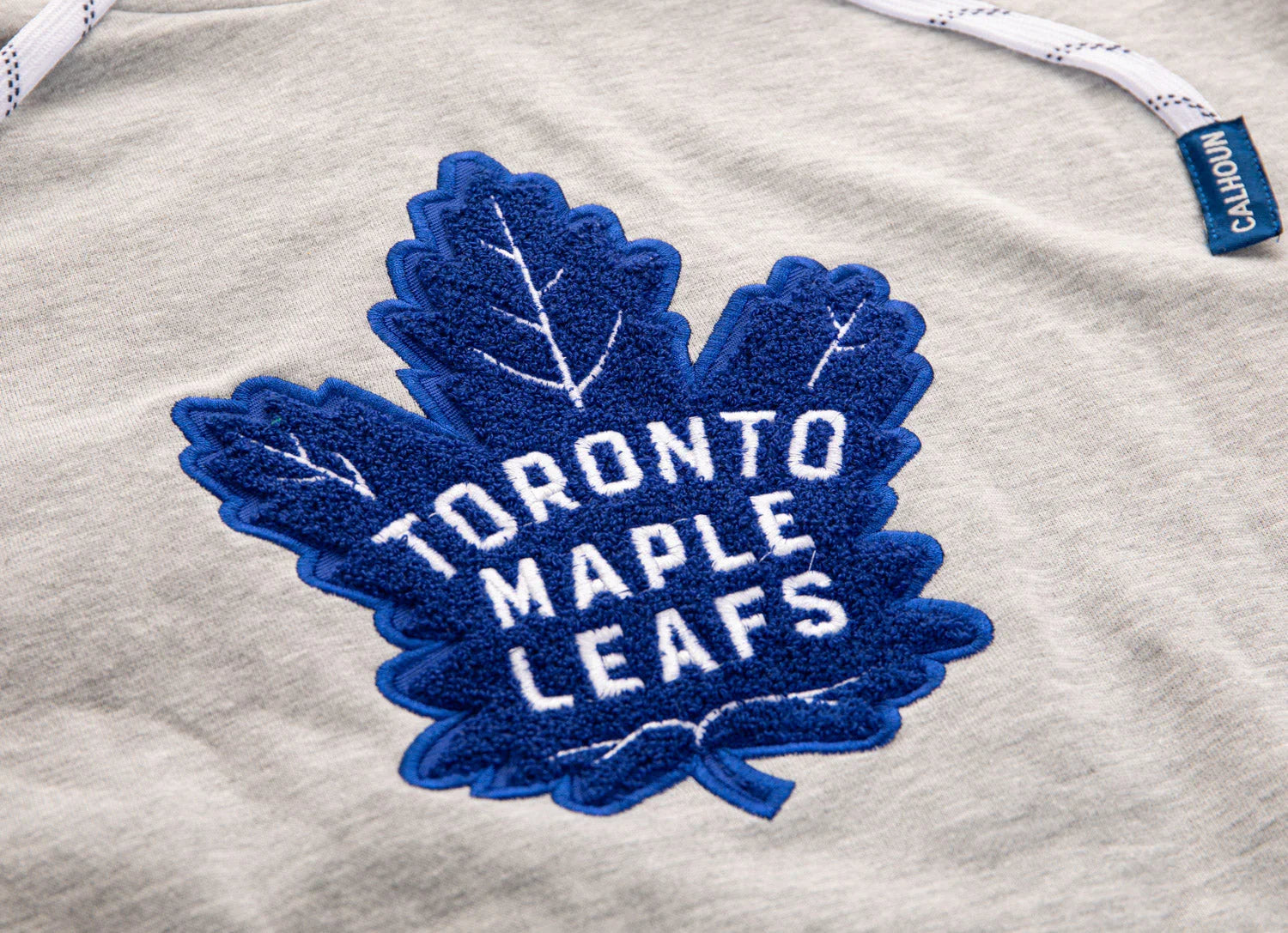 Toronto Maple Leafs blue chenille patch on grey NHL hoodie with CALHOUN tag