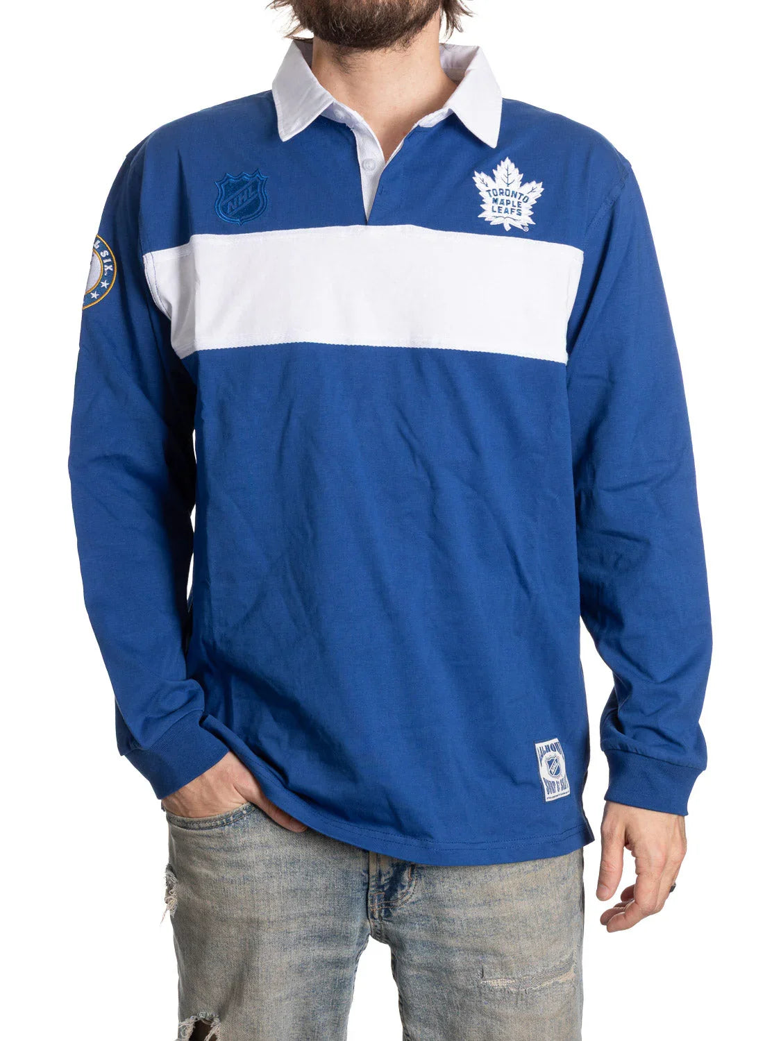 Man wearing Toronto Maple Leafs blue rugby shirt with white stripe, NHL logos, and jeans