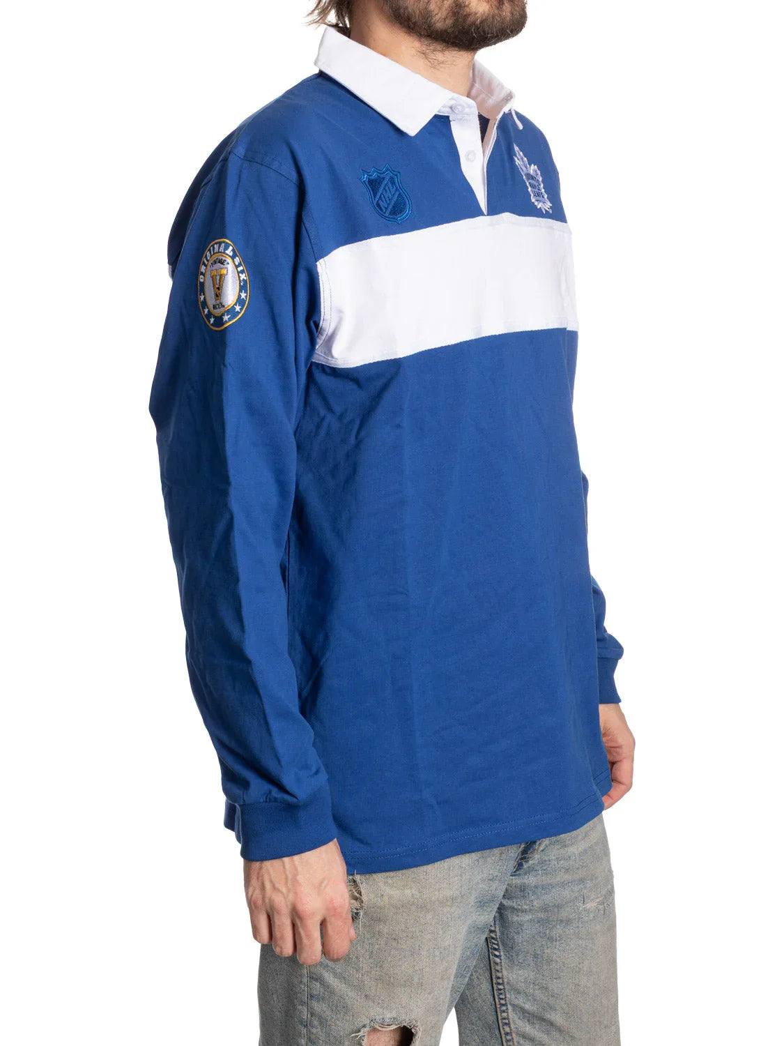 Man wearing blue and white Toronto rugby shirt with patches and distressed jeans