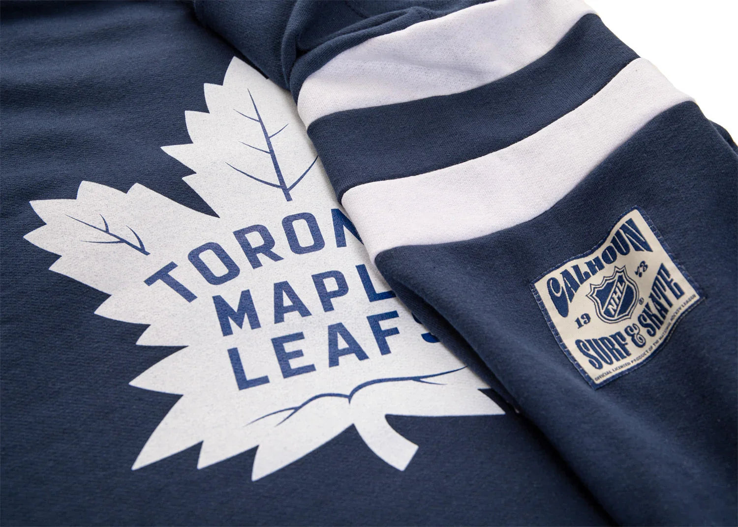 Toronto Maple Leafs varsity sweater detail with leaf logo, sleeve stripes, and Calhoun NHL patch
