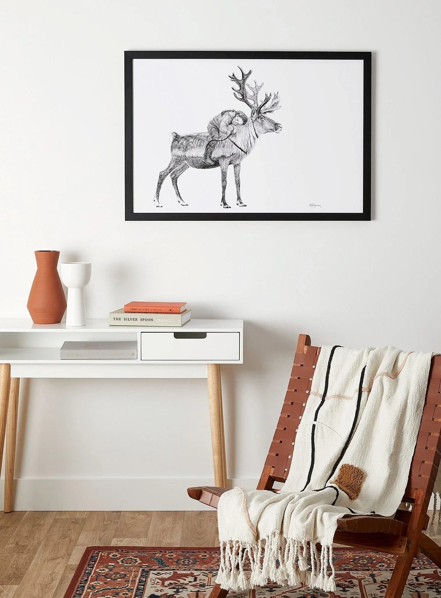 Framed illustration of a Tsaatan girl riding a reindeer, modern wall art in cozy living room