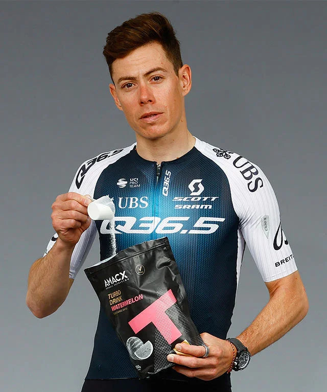 Cyclist in Q36.5 jersey pouring AMACX Turbo Drink Watermelon powder from pouch