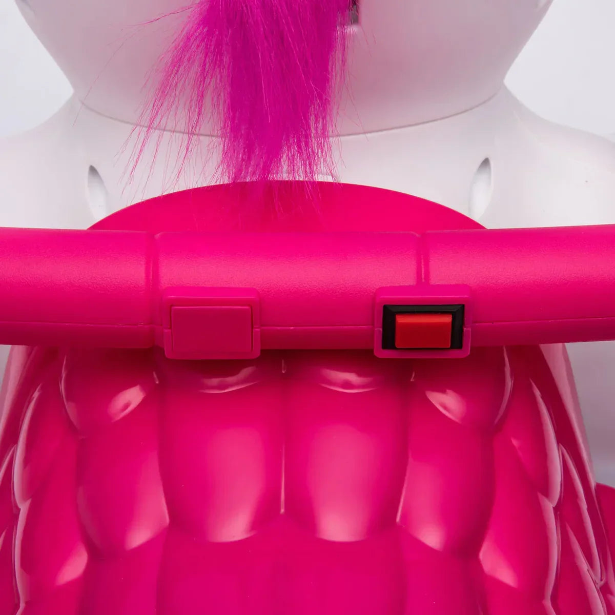 Close-up of pink unicorn ride-on toy with handlebars and red button, kids toy