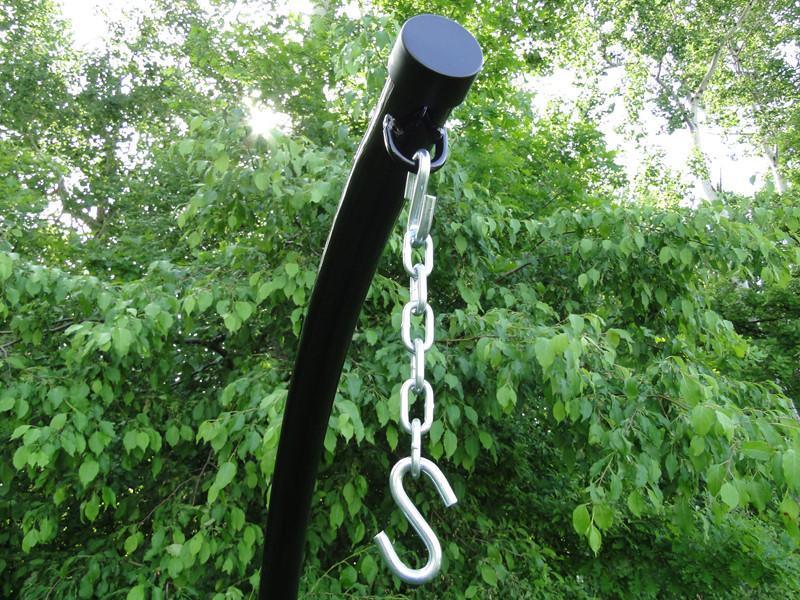 Hammock chair stand top with metal chain and S-hook outdoors, green trees background